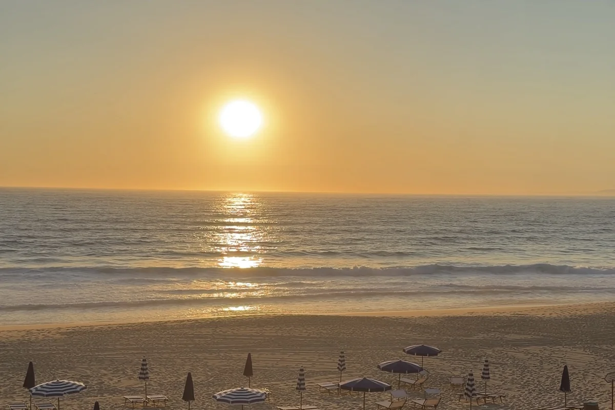 Sunset over the beach at Comporta, umbrellas and loungers set out across the sand.