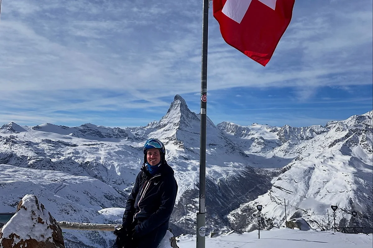 Richard Barningham at a Gornergrat viewpoint with the Swiss flag and the Matterhorn in the background.